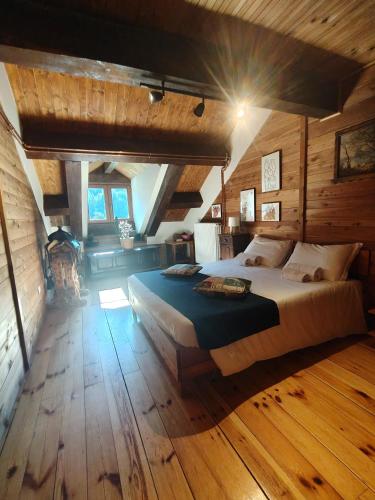a bedroom with a large bed in a room with wooden floors at Rifugio Escursionistico Vernin in Fenils