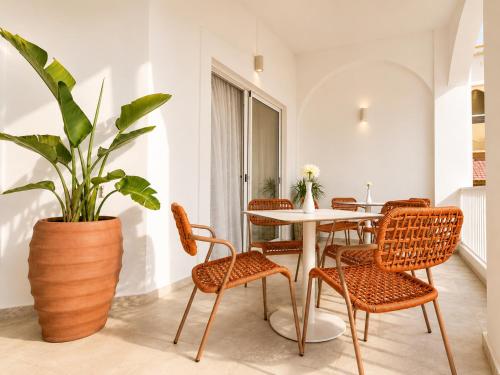 a dining room with a table and chairs and a plant at Melitti Lucent in Rethymno