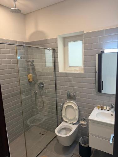 a bathroom with a shower and a toilet and a sink at Hawana Studio SL-3 in Wādī Khasbar