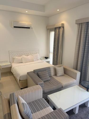 a living room with a bed and a couch at Hawana Studio SL-3 in Wādī Khasbar