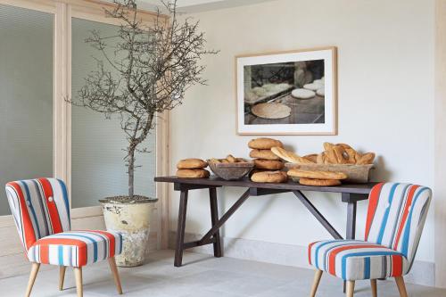 a table with baskets of bread and two chairs at Artesa Suites & Spa in Santo Tomé del Puerto