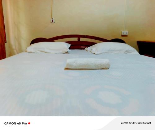 a bed with two pillows on top of it at 0YE' Hotel in Ashalebotwe