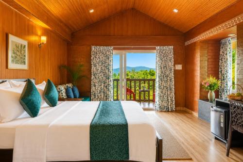 a bedroom with a bed and a balcony at Nature Trails Rock Valley, Goa in Ponda