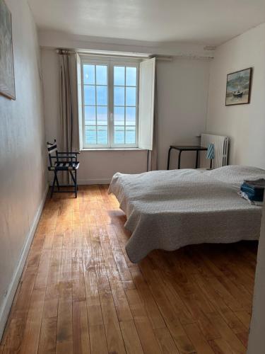 a bedroom with a bed and a large window at FACE A LA MER , L ARTISTE in Ambleteuse