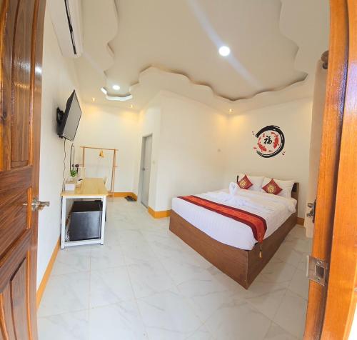 a bedroom with a bed and a tv in it at ฮ่องเต้รักไทยรีสอร์ท in Ban Rak Thai