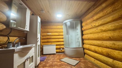 a bathroom with a shower with wooden walls at Hotel Berloga-Sinevir in Synevyrsʼka Polyana