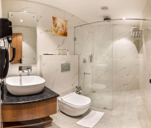 a bathroom with a sink and a toilet and a shower at Lords Inn Katra in Jāmb