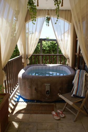 a large bath tub sitting on a porch with a chair at Olive Tree House in Anoyira