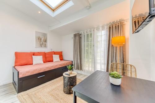 a living room with a couch and a table at Bright studio - RER B - Plateau de Saclay in Palaiseau