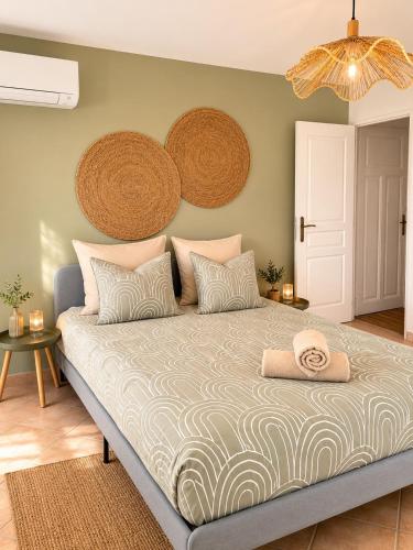 a bedroom with a large bed with a hat on it at La Maison du Cerisier in Manosque