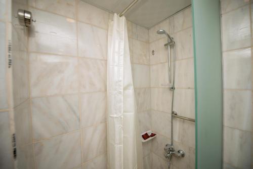 een douche met een douchegordijn in de badkamer bij فندق الأصيل ألوان الفندقية in Mekka