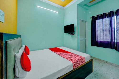 a bedroom with a bed with red and white sheets at Hotel O City View in Dānāpur