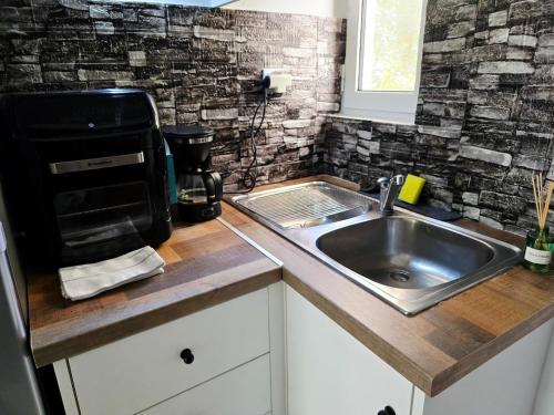 a kitchen with a sink and a coffee maker at The Garden Studio - Spacious Balcony in Lamía