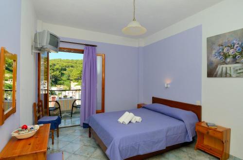a bedroom with a bed and a table and a window at Anais Studios in Patitiri