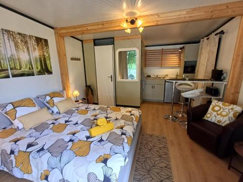 a bedroom with a large bed and a kitchen at Camping Etang Du Camp in Sénergues