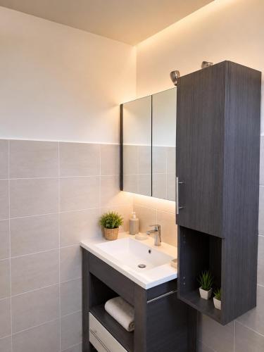 a bathroom with a sink and a mirror at La Maison du Cerisier in Manosque