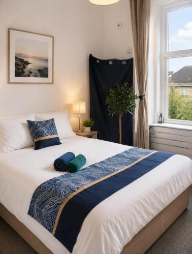 a bedroom with a large bed with a window at Comfortable 2-Bed Flat with Free Parking in Paisley