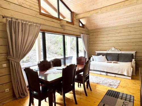 a dining room with a table and chairs and a bed at Hotel Berloga-Sinevir in Synevyrsʼka Polyana