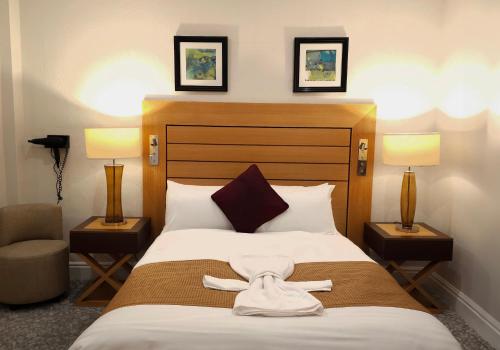 a hotel room with a bed with a robe on it at The Crown Hotel in Stone