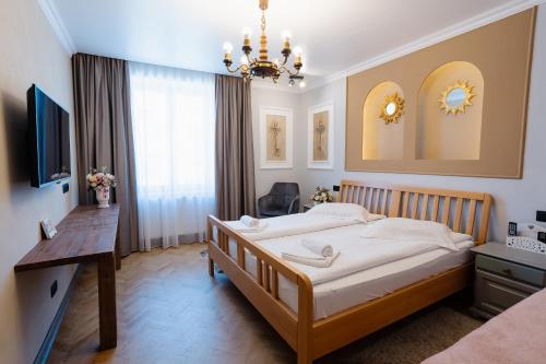 a bedroom with a bed and a desk and a television at Vila Sibiu in Sibiu