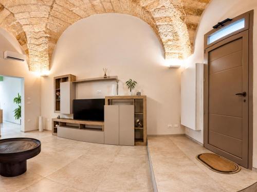 a large living room with a tv and a door at L altra Volta in San Pietro Vernotico