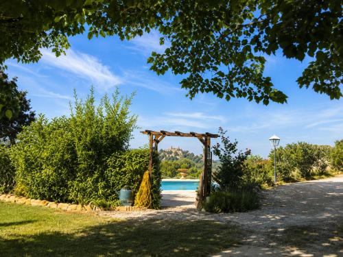 a garden wedding arch with a pool in the background at L'Eden in Ansouis