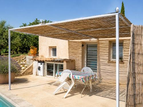 a patio with a table and chairs next to a house at L'Eden in Ansouis