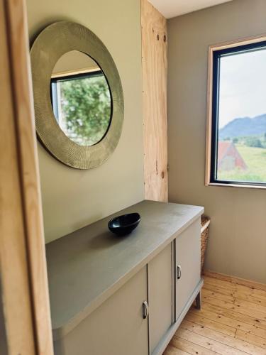 a bathroom with a mirror and a sink on a counter at Nykmark Eco Residence in Unnstad