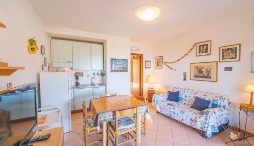 a kitchen and living room with a table and a couch at Appartamento Vista Nel Mare Blu in Rio nellʼElba