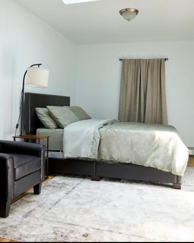 a bedroom with a bed and a chair at SEVENeCOZY in Edgemere