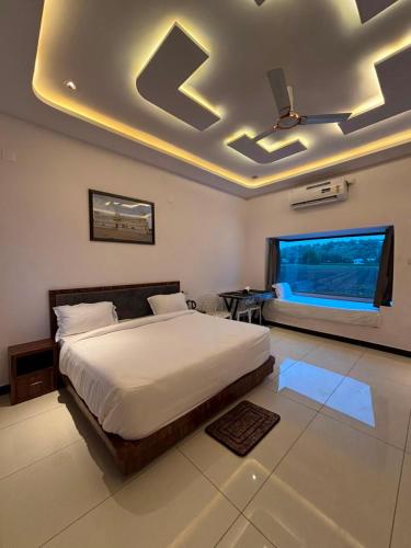 a bedroom with a large bed and a window at Marudhar Resort in Chittaurgarh