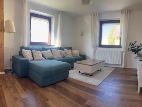 a living room with a blue couch and a coffee table at Eifel Moments in Kall