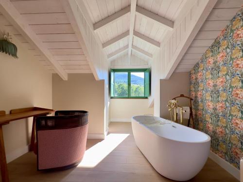 a bathroom with a large tub and a window at La Casa de las Flores in Noceda del Bierzo