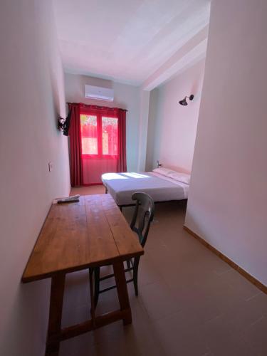 a room with a table and a bed and a desk at Domu hermosa in Villaputzu