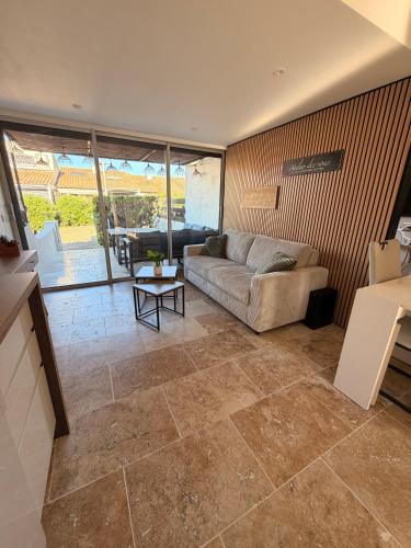a living room with a couch and a table at Sexty-nine, villa 69 héliovillage in Cap d'Agde