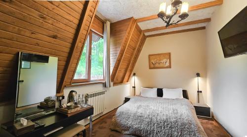 a bedroom with a large bed and a mirror at Alpine Castle Hotel in Dilijan