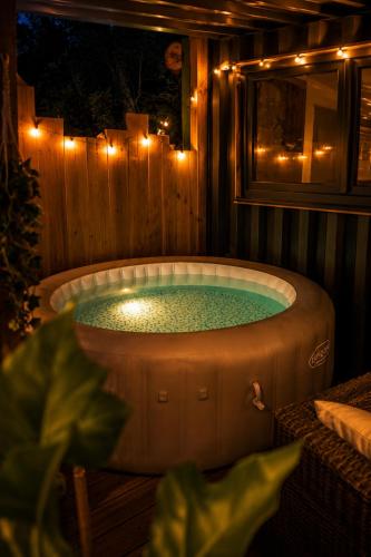 a jacuzzi tub in a backyard with lights at Ô Temps Des Pins in Éguilles