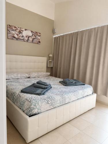 a bedroom with a bed with two towels on it at Monolocale in un piccolo paradiso in Tramatza