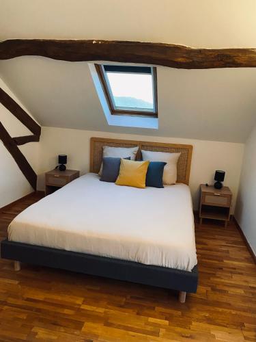 a bedroom with a large bed with a window at Gîte des Charbonneaux in Avrée