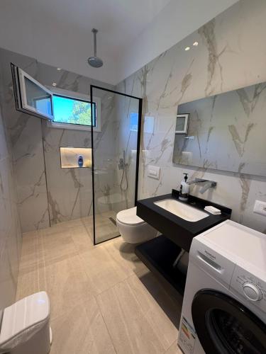 a bathroom with a toilet and a sink and a shower at Rajan Villas in Vlorë