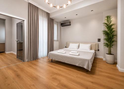 a bedroom with a bed with two towels on it at ICONIC LEGACY Suite seafront in Thessaloniki