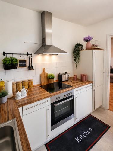 a kitchen with white cabinets and a stove top oven at Modern Comfort Apartment with Balcony in Dresden