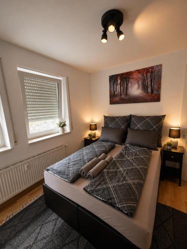 a large bed in a bedroom with two windows at Modern Comfort Apartment with Balcony in Dresden