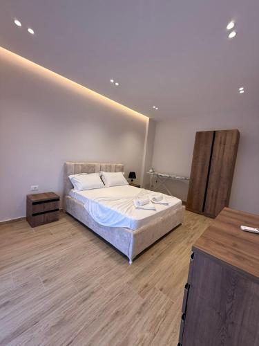 a bedroom with a large bed and a wooden floor at Rajan Villas in Vlorë