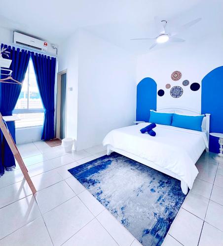 a blue and white bedroom with a bed and a rug at Santorini Vibes Penang - Tasek Gelugor in Kampong Selamat