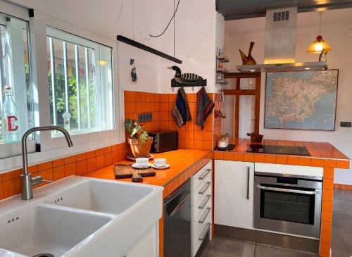 a kitchen with a white sink and orange tiles at Casa Roja Sigüenza in Sigüenza