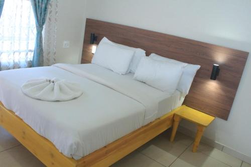 a bedroom with a large bed with a wooden headboard at Prax Guest House Benoni in Benoni