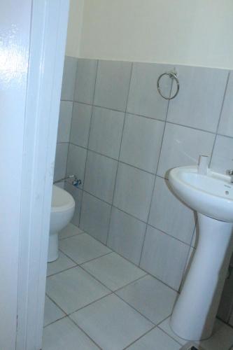 a bathroom with a toilet and a sink at Prax Guest House Benoni in Benoni