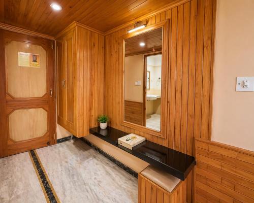 a room with a mirror and a wooden wall at Hotel Hollywood Manali - Scenic River & Mountain View With Premium Rooms Near Mall Road in Manāli