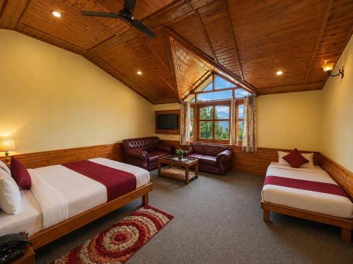 a bedroom with two beds and a living room at Hotel Hollywood Manali - Scenic River & Mountain View With Premium Rooms Near Mall Road in Manāli